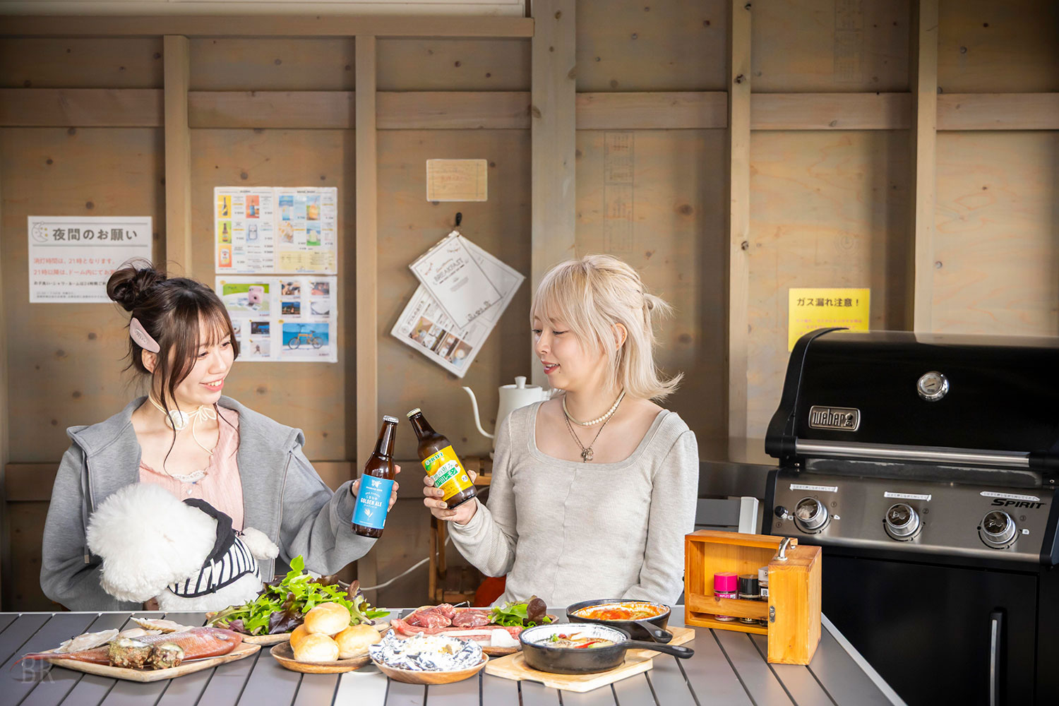グランヴィレッジ瀬戸内しまなみの全天候型BBQスペースでBBQと地元のドリンクを楽しむ女性